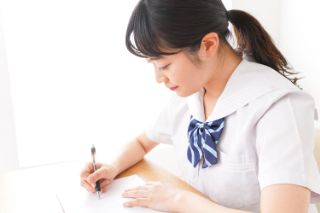 紙にメモを書く学生